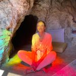 Sound healing Webinar 3 (of 8) Photo of Githa Ben-David sitting in rainbow coloured light. Click image to book the series of 10 online sound scanning sessions.